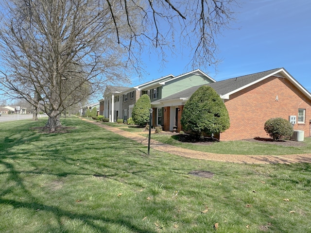 view of side of property with a lawn and cooling unit