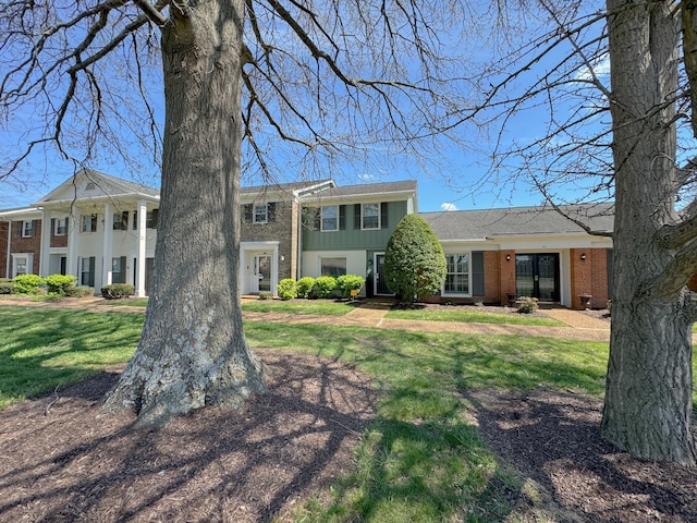 neoclassical home featuring a front lawn