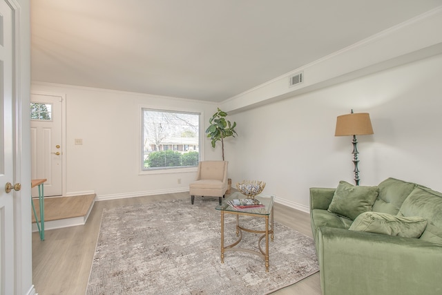 living room with light hardwood / wood-style floors and crown molding