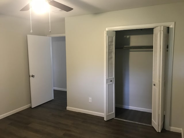 unfurnished bedroom featuring a closet, dark hardwood / wood-style floors, and ceiling fan