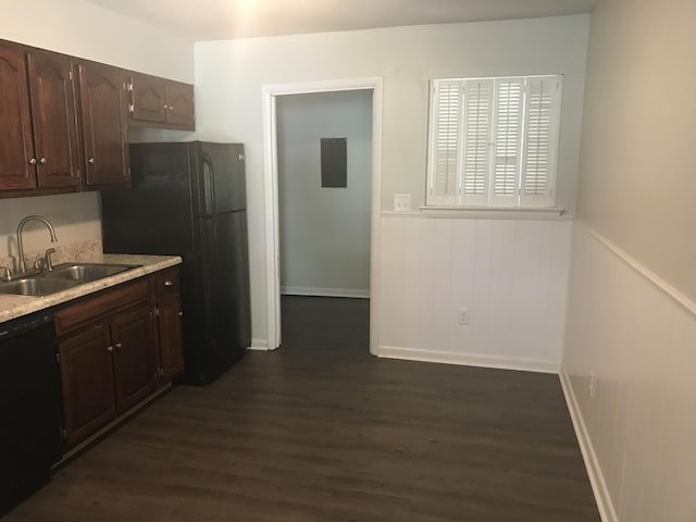 kitchen featuring dark hardwood / wood-style flooring, dark brown cabinetry, black appliances, and sink