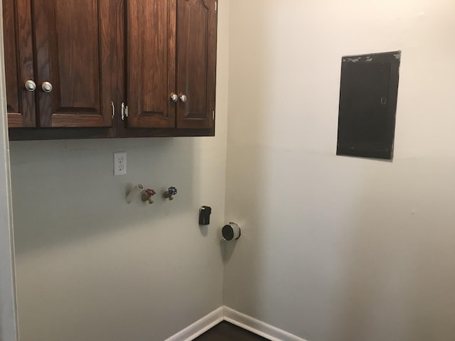 washroom with electric panel and cabinets