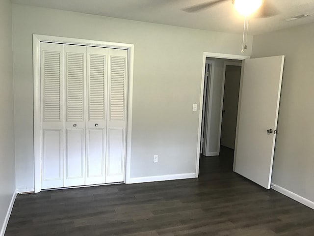 unfurnished bedroom featuring a closet, ceiling fan, and dark hardwood / wood-style flooring