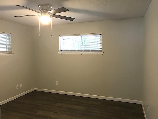 spare room with dark hardwood / wood-style floors and ceiling fan