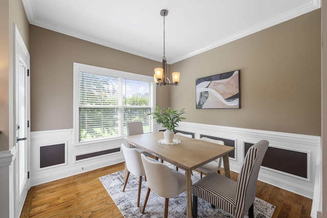 dining room featuring a chandelier, hardwood / wood-style flooring, and ornamental molding