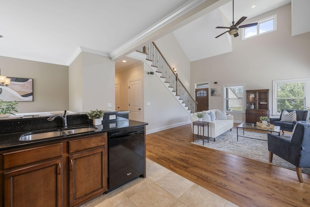 kitchen featuring sink, light wood-type flooring, black dishwasher, and a wealth of natural light