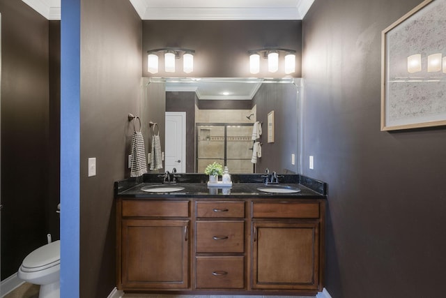 bathroom featuring vanity, toilet, a shower with door, and crown molding