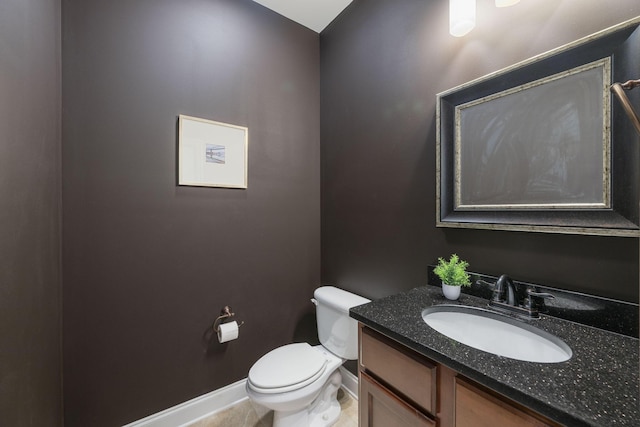 bathroom with tile patterned flooring, vanity, and toilet