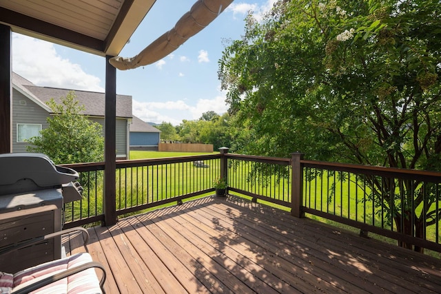 wooden terrace featuring a lawn and area for grilling