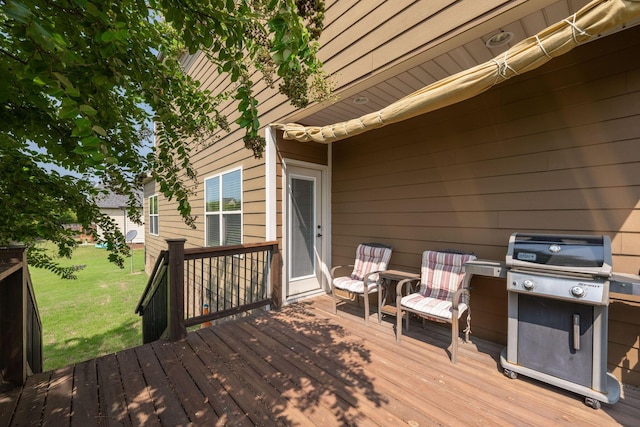 wooden terrace featuring a yard and grilling area