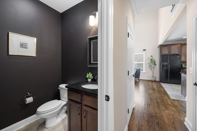 bathroom featuring vanity, wood-type flooring, and toilet