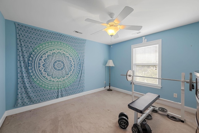 exercise area with ceiling fan and carpet