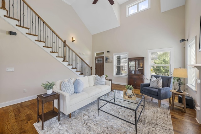 living room featuring ceiling fan, hardwood / wood-style floors, and a high ceiling