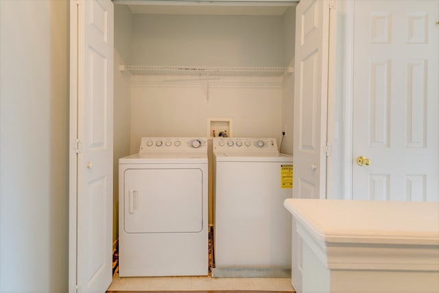 clothes washing area featuring washer and dryer and light tile patterned flooring