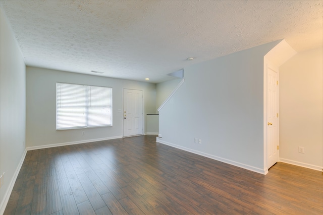 unfurnished room with dark wood-type flooring and a textured ceiling