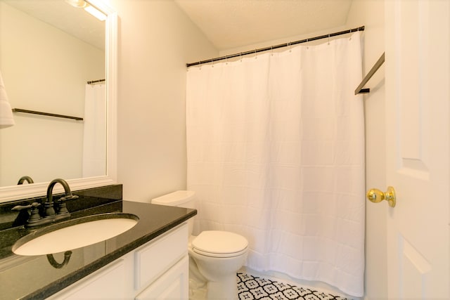 bathroom featuring vanity, a textured ceiling, and toilet