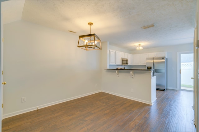 interior space featuring a textured ceiling, dark wood-type flooring, and a chandelier