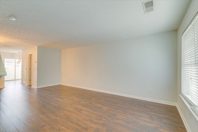 unfurnished room featuring a textured ceiling and dark hardwood / wood-style flooring