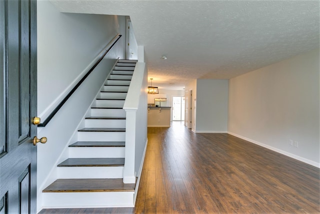 3425 Harpeth Springs Dr, Nashville, TN 37221 - stairway featuring a textured ceiling, wood finished floors, and baseboards