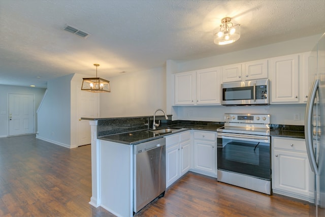 kitchen featuring kitchen peninsula, stainless steel appliances, sink, dark hardwood / wood-style floors, and white cabinetry