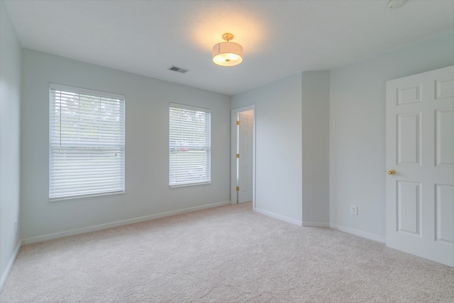 unfurnished room featuring light carpet and a healthy amount of sunlight