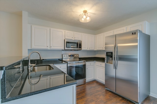 kitchen with white cabinets, kitchen peninsula, sink, and appliances with stainless steel finishes