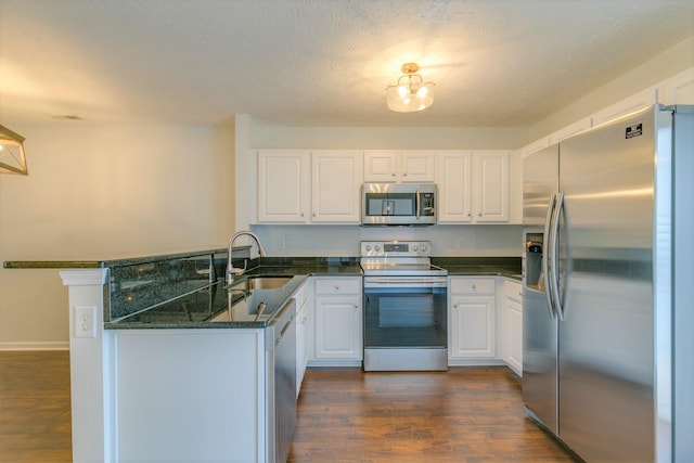 3425 Harpeth Springs Dr, Nashville, TN 37221 - kitchen with appliances with stainless steel finishes, a sink, a peninsula, white cabinetry, and dark wood-type flooring