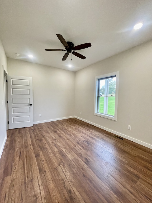 empty room with hardwood / wood-style floors and ceiling fan