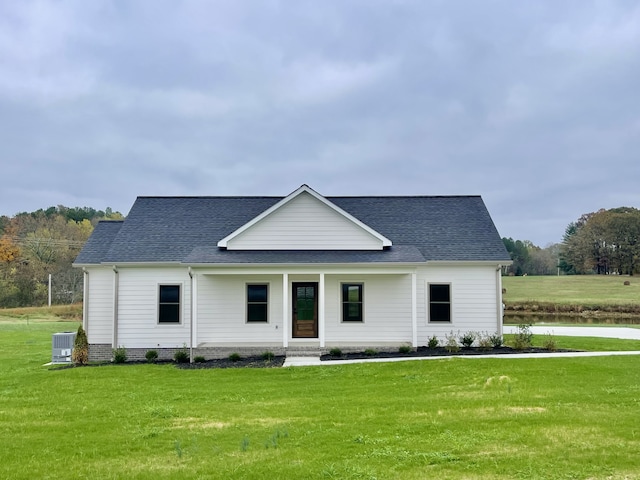 view of front facade with central AC unit, a porch, and a front lawn