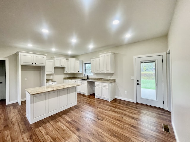 kitchen with hardwood / wood-style floors, a healthy amount of sunlight, and white cabinetry