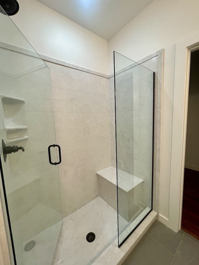 bathroom with tile patterned floors and a shower with door