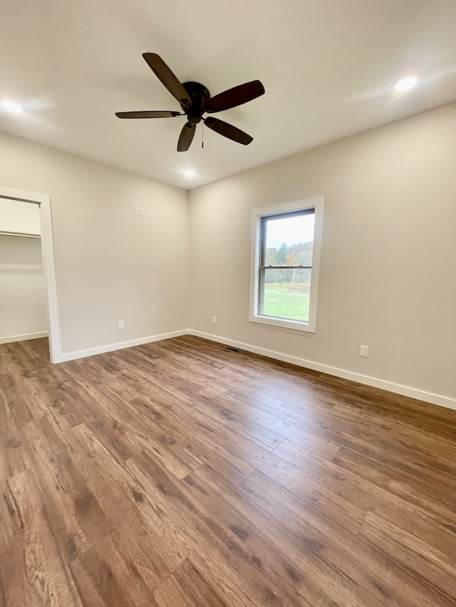 empty room with ceiling fan and wood-type flooring