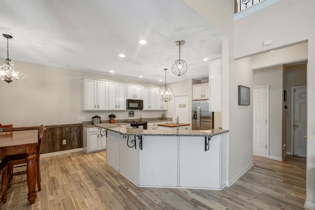 kitchen featuring black appliances, light stone countertops, and white cabinetry