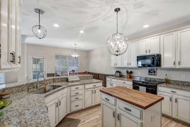 kitchen featuring sink, a center island, black appliances, and light hardwood / wood-style floors