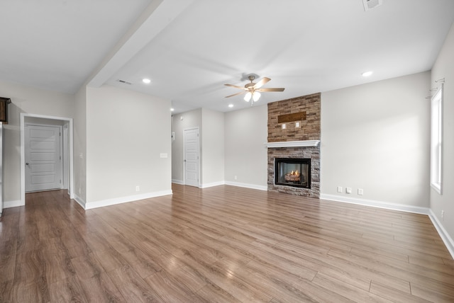 unfurnished living room with ceiling fan, light hardwood / wood-style floors, and a fireplace