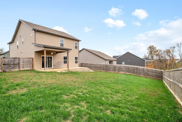 back of property featuring ceiling fan, a yard, and a patio