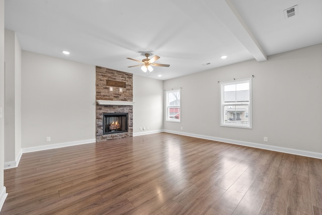 unfurnished living room with beamed ceiling, a fireplace, dark wood-type flooring, and ceiling fan