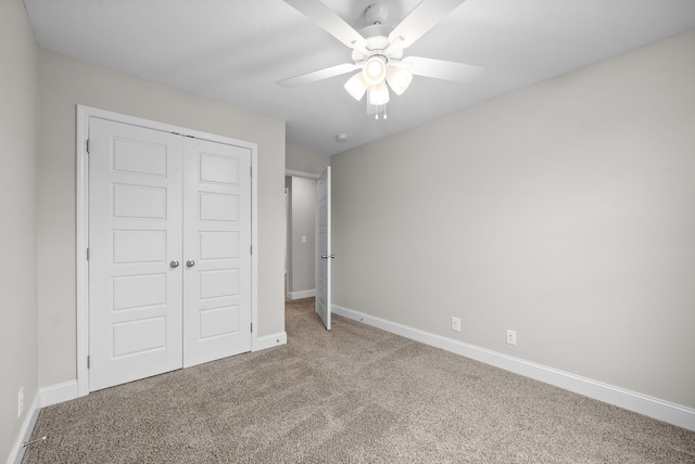 unfurnished bedroom with carpet, ceiling fan, and a closet