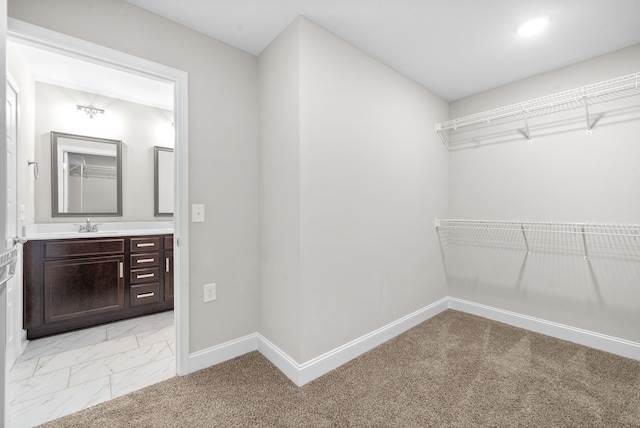 spacious closet with sink and light colored carpet