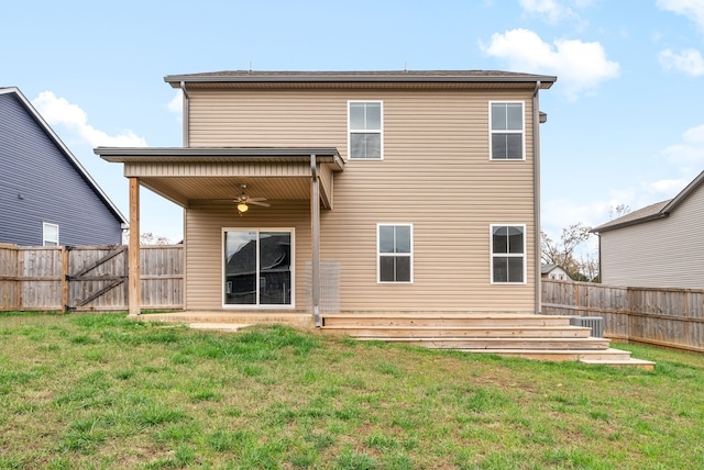 rear view of house with a lawn and ceiling fan