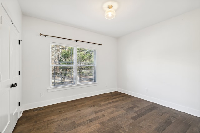 empty room with dark hardwood / wood-style flooring