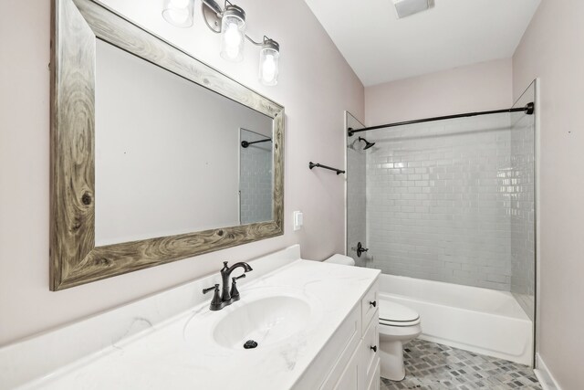 full bathroom with tiled shower / bath, tile patterned flooring, vanity, and toilet