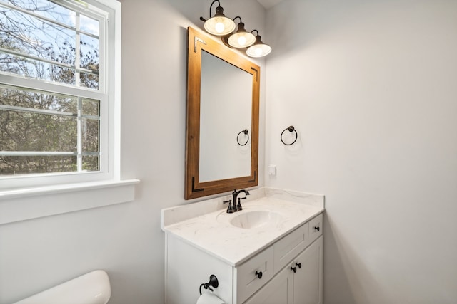 bathroom featuring vanity, toilet, and plenty of natural light