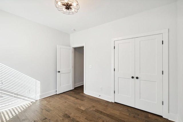 unfurnished bedroom with a closet and dark wood-type flooring