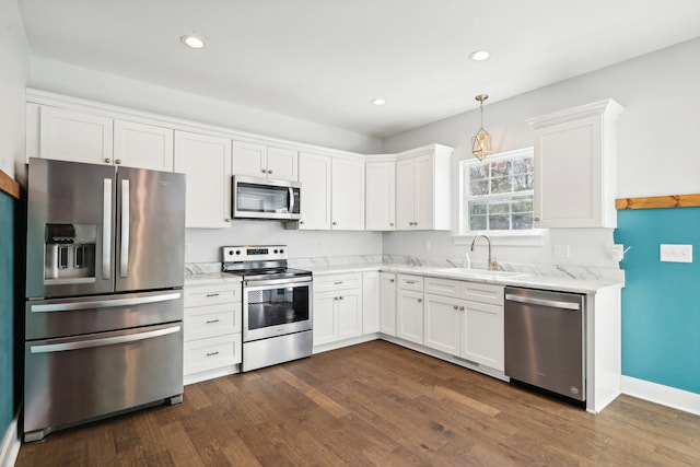 kitchen with dark wood-type flooring, white cabinets, pendant lighting, and appliances with stainless steel finishes