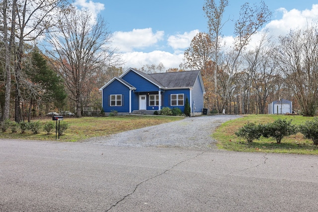 view of front of house with a shed and a front lawn