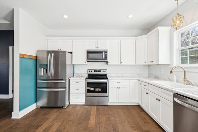 kitchen with dark hardwood / wood-style flooring, stainless steel appliances, sink, decorative light fixtures, and white cabinetry