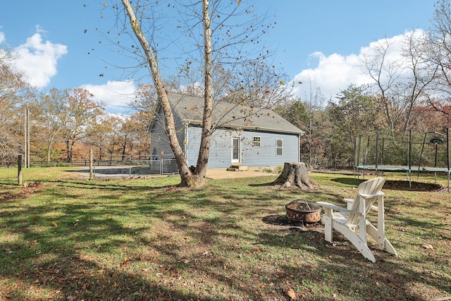 view of yard featuring a trampoline and a fire pit