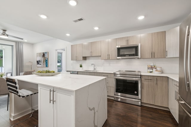 kitchen with dark hardwood / wood-style flooring, a center island, stainless steel appliances, and a wealth of natural light