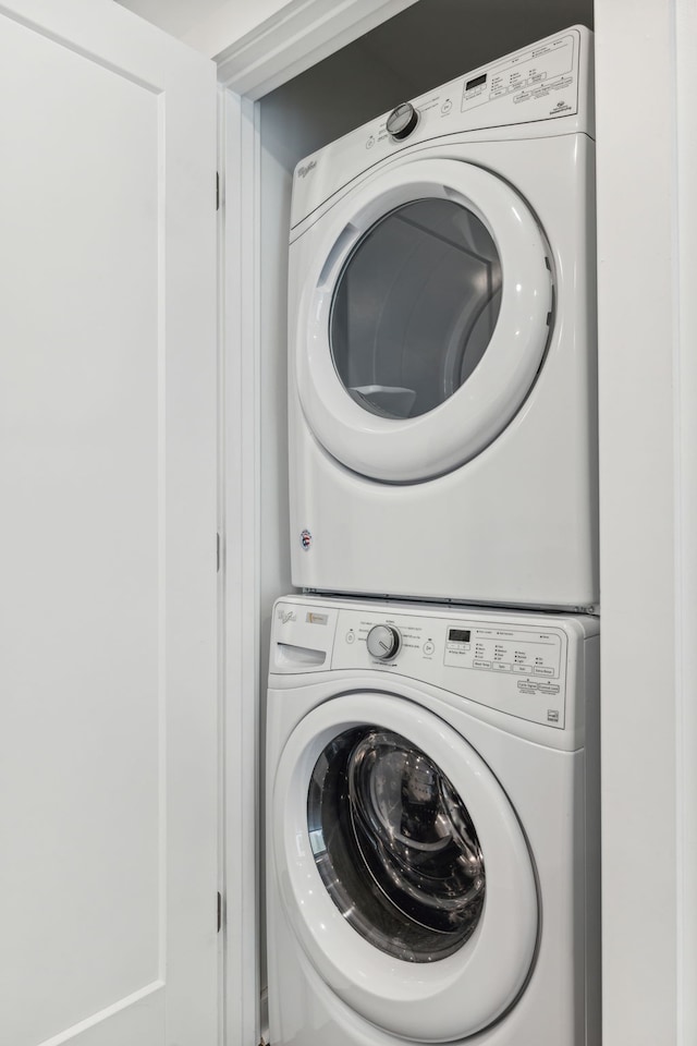 clothes washing area with stacked washer and clothes dryer